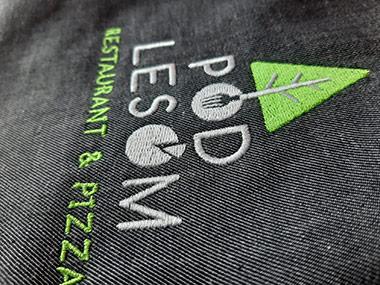 Strojové vyšívané logo na pracovnom oblčení z našej dielne má aj reštaurácia POD LESOM